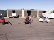 Gyrocopters parked outside hangar building