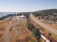 Aerial of highway, train, river, buildings in background