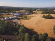 Open field next to property with buildings and highway