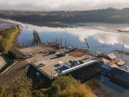 River and small dock with boathouses, sky, trees