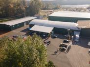 Industrial buildings, parking lot with cars, trees