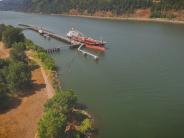 Large ship at dock, river, trees