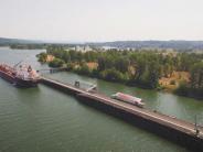 Large ship at dock, river, trees and sky