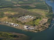 Aerial of river, shipping dock, industrial buildings and farmland in the background