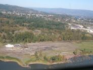 Aerial photo of river and land with trees and buildings