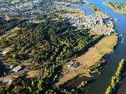 Aerial photo of river and land with trees and buildings