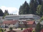 Exterior of school building with other buildings and trees in background