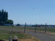 Fence, airplane flying above in the clear blue sky