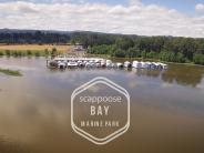 River with boat houses at marina, trees, sky