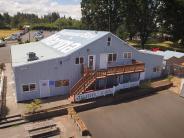 Exterior of the Scappoose Bay Paddling Center building, parked cars