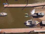 Aerial of two boats being loaded onto trailers at boat ramp, two kayakers