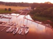 Docks with boats tied up, boat launch, sunset, trees