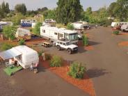Trailers in the RV park, vehicles parked, trees