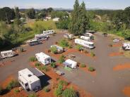 Aerial of campground with RVs parked, trees, sky