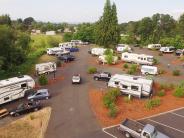 Trailers parked at RV park, vehicles, trees, sky