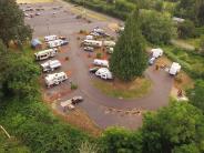Trailers parked at RV park, vehicles, trees
