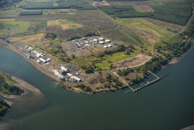 Aerial of river, shipping dock, buildings, and open acreage in the background
